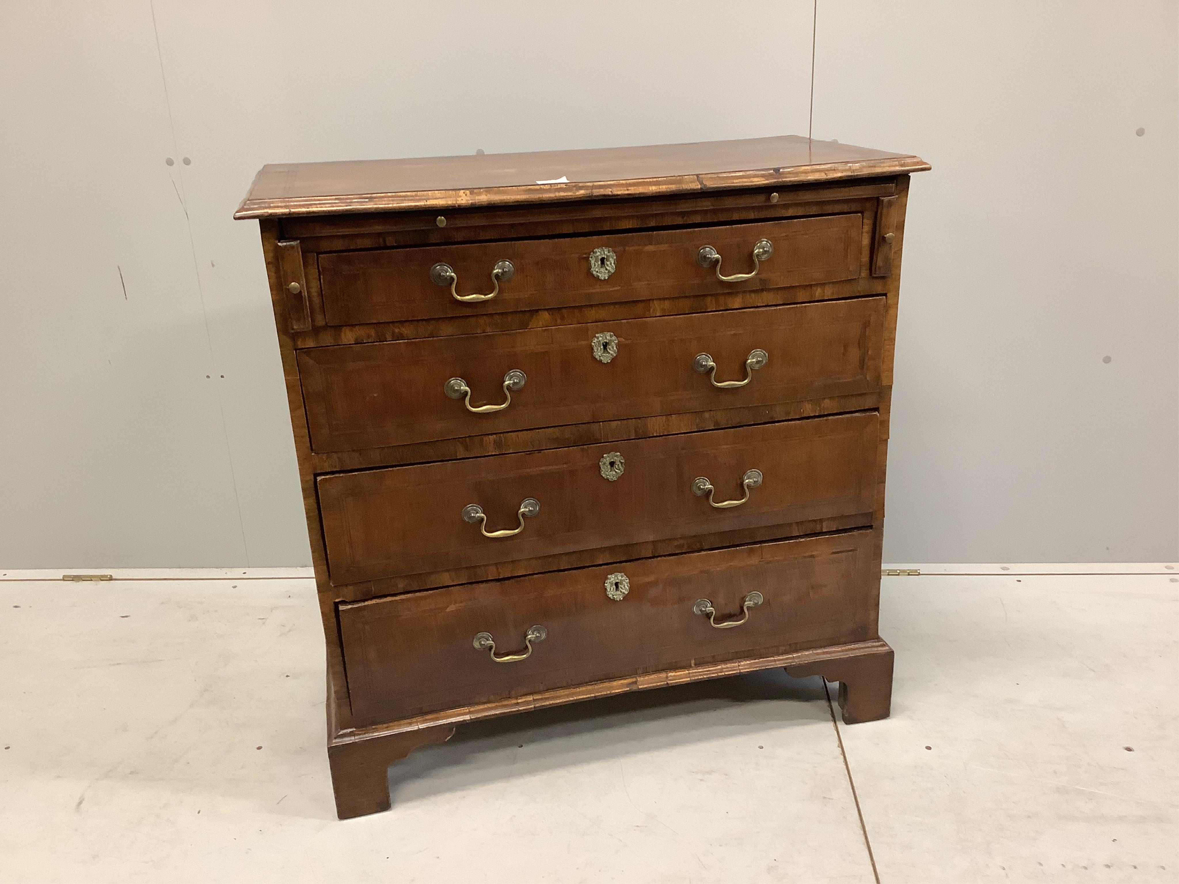 A mid 18th century feather banded walnut chest, fitted four long drawers, beneath a brushing slide, width 92cm, depth 48cm, height 92cm. Condition - fair